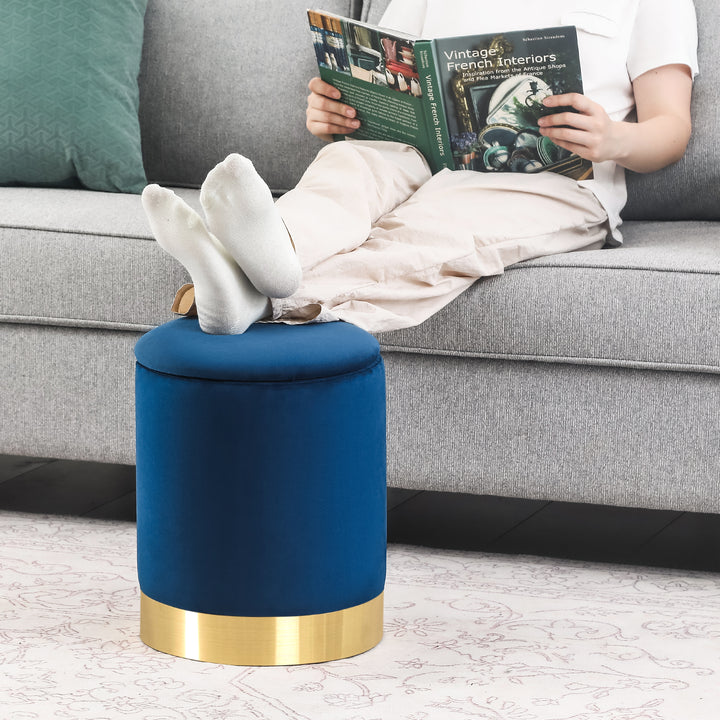 Round velvet storage ottoman with gold base, padded footrest.